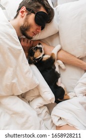 Man Sleeping With Dog In White Bed