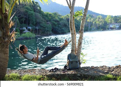 Man Sleeping In A Hammock At The Beach