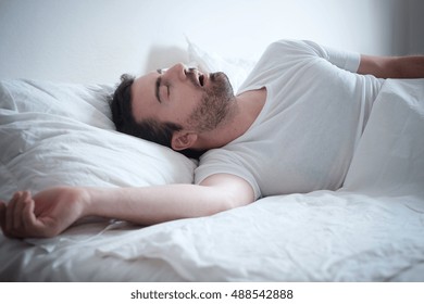 Man sleeping in his bed and snoring loudly