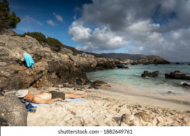Man sleeping on beach with hat on his face