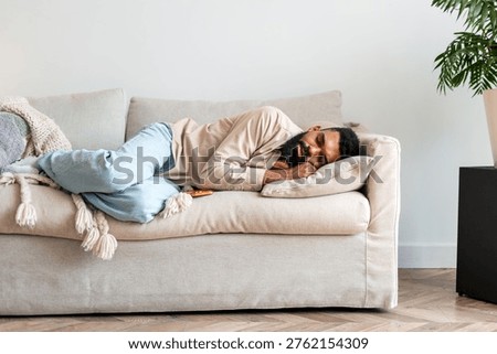 Man sleeping on a comfortable sofa, recovering from fatigue, enjoying a peaceful moment at home