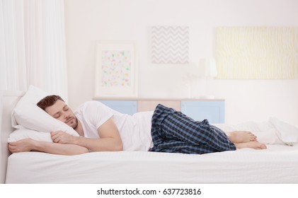 Man Sleeping On Two Pillows At Home. Incorrect Sleep Posture Concept