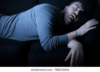 Man Sleeping And Snoring On The Sofa At Night