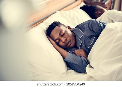 A Man Sleeping Soundly In Bed