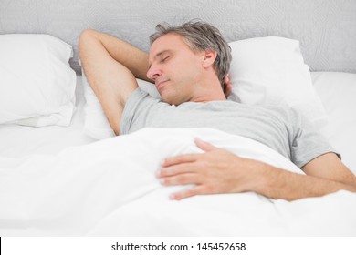 Man Sleeping Soundly In His Bed At Home