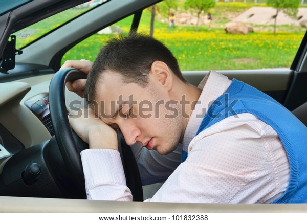 Man sleeps in a\
car.