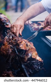 A man slicing grilled pig