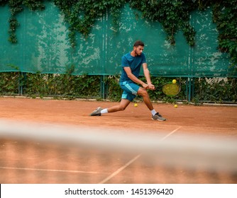 Man slides to hit a ball on the rise, performing good footwork. Agility and perfect defence techniques. Tennis, racket sports. - Powered by Shutterstock