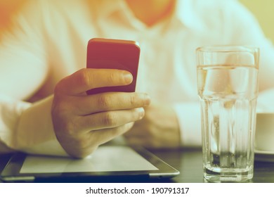 Man With Smart Phone In Hand, Blurred Background, Glass Of Wather