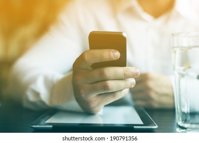 Man With Smart Phone In Hand, Blurred Background, Glass Of Wather