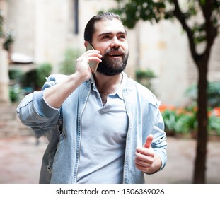 Man with smartphone calling on city street  - Shutterstock ID 1506369026