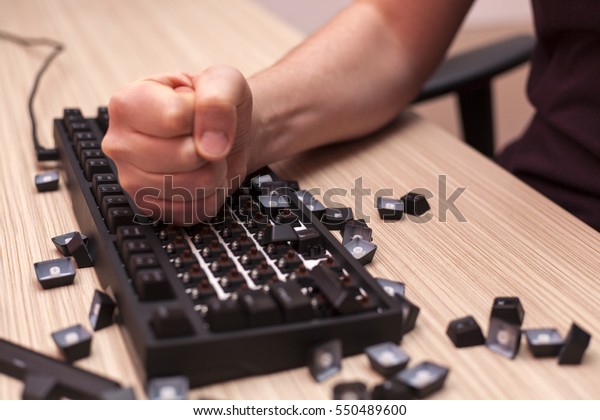Man smashes a mechanical computer keyboard in rage\
using one fist