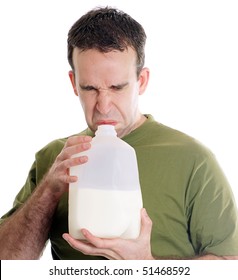 Man Smelling A Container Of Milk And Discovering It Is Spoiled, Isolated Against A White Background