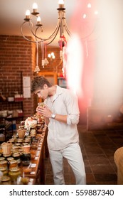 Man Smelling Preserves In Grocery