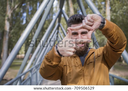 young man simulating a photographic frame with his hands