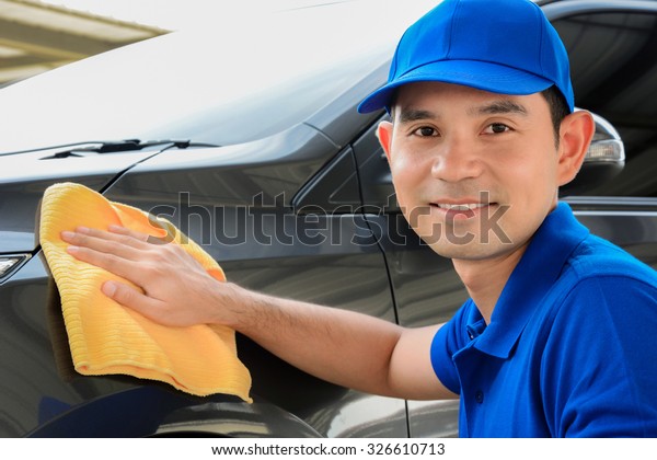 A man with smiling\
face cleaning car