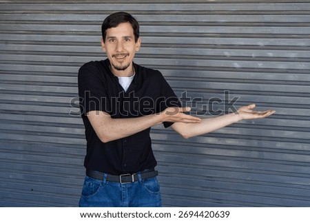 Man smiling and gesturing, presenting empty space