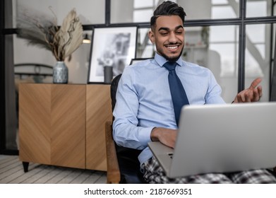 Man smiling at laptop sitting in chair