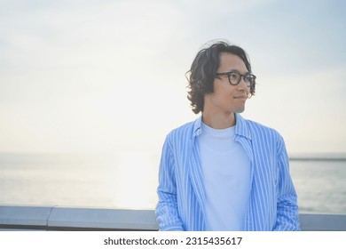 A man smiling on a bridge with the setting sun at his back - Powered by Shutterstock