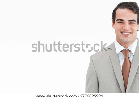 Man smiling and posing in studio wearing light gray suit white shirt brown tie, copy space. Headshot, executive, corporate, professional, portrait, minimalist, highkey