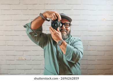 Man smiling while holding camera to take photo.