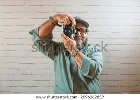 Man smiling while holding camera to take photo.
