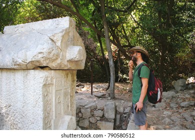 Man Smiling While Inspecting an Ancient Tomb
