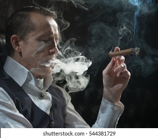 A Man Smokes A Cigar And The Smoke Released From The Mouth