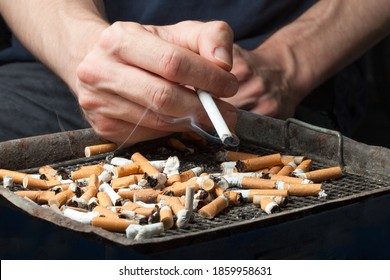 Man Smoking A Cigarette Above An Ash Tray