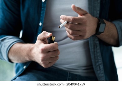 Man smoking cigarette at home. Addiction to nicotine, mental, problems and troubles, bad habit and worry. Sad unhappy millennial european guy lights cigarette, cropped, close up, empty space - Powered by Shutterstock