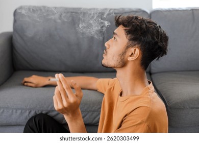 Hombre fumando cigarrillo en la sala de estar