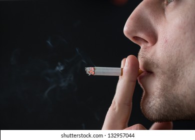 Man Smoking Cigarette On Black Background