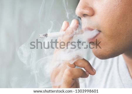 man smoking a cigarette. Cigarette smoke spread. 