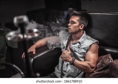 Man Smoking Hookah In The Shisha Bar.