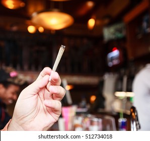 Man Smoking Marijuana Cigarette In Coffee Shop In Amsterdam, Netherlands 