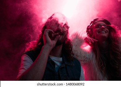 Man Smoking Marijuana Joint Near Smiling Girl In Nightclub