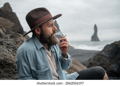 Man Smoking Weed And Blowing Puffs Of Smoke While Resting At The Foggy Beach