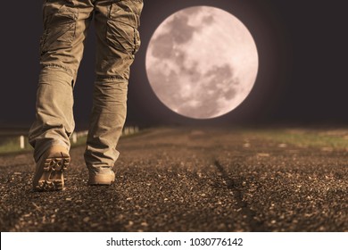 A Man And Sneaker Shoes Walking Under Full Moon At Night