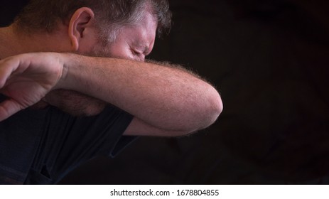 A Man Sneezes Using His Inner Elbow For Protection