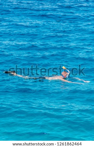 man with snorkel mask tuba and snorkel in sea. Snorkeling, swimming, vacation. Tourists are engaged in snorkeling in the open sea. Holidays in the seaside resort. vertical photo