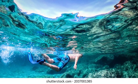 Man Snorkeling In The Blue Sea On A Sunny Day In Sardinia, Italy