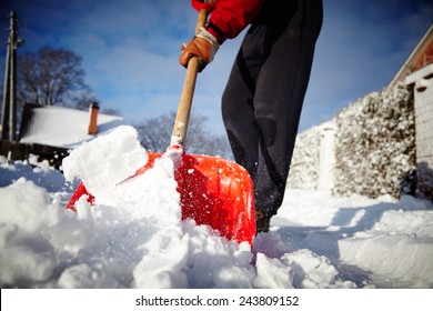 Man with snow shovel cleans sidewalks in winter. Winter time. Latvia. Europe. 