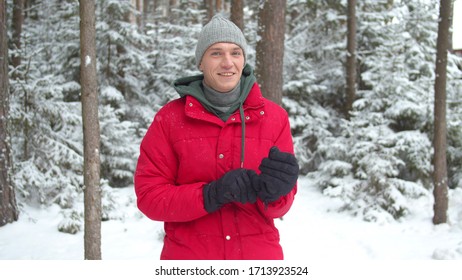 A Man In A Snowy Forest Puts On Winter Gloves