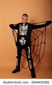 a man with social problems stuck in a web in a skeleton costume for Halloween advertising for shopping centers