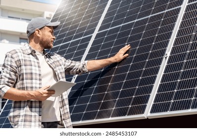 Man solar panel maintenance specialist with digital tablet touching surface of solar panel with his hand. - Powered by Shutterstock