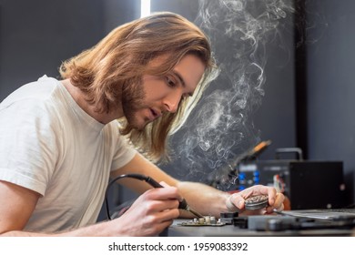 Man With Soldering Iron And Box Of Solder