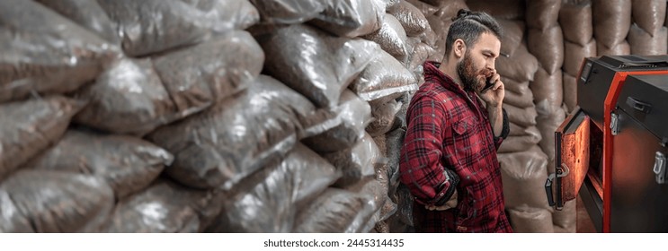 A man with a solid fuel boiler, working on biofuel, economical heating.
