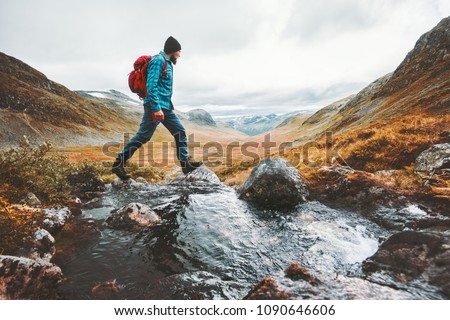 Man solo traveling backpacker hiking in scandinavian mountains active healthy lifestyle adventure journey vacations