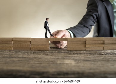 Man solving problems by building bridge with wooden block to span a gap for little businessman walking across. - Powered by Shutterstock