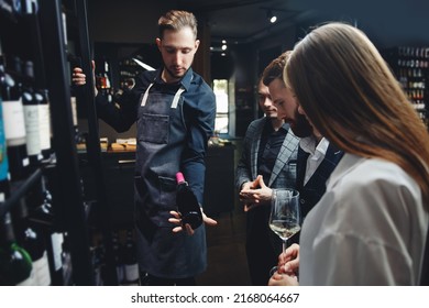 Man sommelier helps visitors to restaurant or liquor store to choose bottle of wine. - Powered by Shutterstock